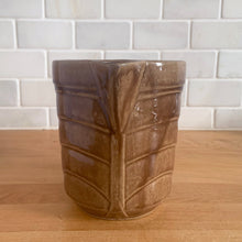 Load image into Gallery viewer, Vintage glossy light brown stoneware pitcher with stacked chevron detail. Crafted by Monmouth Western Stoneware, USA, 1920s. Add this utilitarian piece to your farmhouse decor or art pottery collection!
In excellent condition, no chips/cracks/repairs, age-related crazing. Unmarked.
Measures 4 1/2 x 5 inches