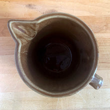 Load image into Gallery viewer, Vintage glossy light brown stoneware pitcher with stacked chevron detail. Crafted by Monmouth Western Stoneware, USA, 1920s. Add this utilitarian piece to your farmhouse decor or art pottery collection!
In excellent condition, no chips/cracks/repairs, age-related crazing. Unmarked.
Measures 4 1/2 x 5 inches