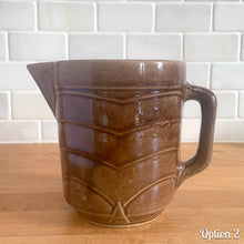 Load image into Gallery viewer, Vintage gloss brown stoneware pitcher with stacked chevron detail. Crafted by Monmouth Western Stoneware, USA, 1920s. Add this utilitarian piece to your farmhouse decor or art pottery collection!
In as found vintage condition, chip to the spout, no cracks/repairs, age-related crazing. Unmarked.
Measures 4 1/2 x 5 inches