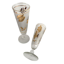 Load image into Gallery viewer, If you're a fan of the TV series, Mad Men, then you'll dig these fabulous "Golden Foliage" pilsner or champagne glasses. Crafted by the Libbey Glass Company, circa 1960/70s. Covered in gold leaves on a frosted band bordered with gold bands. These beauties would be a fabulous addition to your barware collection and will definitely amp up the glam of any bar cart. In excellent vintage condition, free from chips or wear. They look brand new!