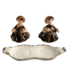 Load image into Gallery viewer, Vintage hand painted Golden Girl ceramic condiment set with tray. Enesco, Japan, 1960s. Add this pretty set to your collection!
In excellent condition, no chips/cracks/repairs.
Each girl measures 2 1/2 x 1 7/8 x 3 1/2 inches
Tray measures 6 1/4 x 2 1/8 inches