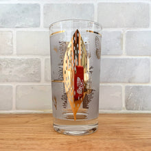Load image into Gallery viewer, A chilled cocktail would complement this vibrant vintage Golden Meadow highball glass tumbler featuring 22kt gold. Designed by Fred Press and produced by the Federal Glass, USA, circa 1960-70. The gold butterfly and botanical details pop off the frosted background.
In excellent condition, no chips, minor spot of wear on one glass.
Measures 2 3/4 x 5 1/8 inches