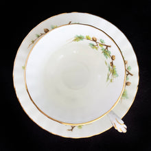Load image into Gallery viewer, This vintage bone china footed teacup and saucer is so sweet! Both the cup and saucer are decorate with the "Goldfinch" pattern from the Woodland Series. Each piece has a lovely scalloped edge featuring a hand painted goldfinch bird with spruce boughs, trimmed with gold gilt. Produced by Royal Albert, England, circa 1917 - 1927. In excellent condition, free from chips, cracks and repairs. Maker's marks are on the bottom. Teacup measures 3 3/8 x 2 3/4 inches | Saucer measures 5 1/4 inches