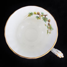 Load image into Gallery viewer, This vintage bone china footed teacup and saucer is so sweet! Both the cup and saucer are decorate with the "Goldfinch" pattern from the Woodland Series. Each piece has a lovely scalloped edge featuring a hand painted goldfinch bird with spruce boughs, trimmed with gold gilt. Produced by Royal Albert, England, circa 1917 - 1927. In excellent condition, free from chips, cracks and repairs. Maker's marks are on the bottom. Teacup measures 3 3/8 x 2 3/4 inches | Saucer measures 5 1/4 inches