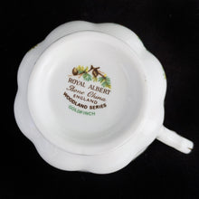 Load image into Gallery viewer, This vintage bone china footed teacup and saucer is so sweet! Both the cup and saucer are decorate with the "Goldfinch" pattern from the Woodland Series. Each piece has a lovely scalloped edge featuring a hand painted goldfinch bird with spruce boughs, trimmed with gold gilt. Produced by Royal Albert, England, circa 1917 - 1927. In excellent condition, free from chips, cracks and repairs. Maker's marks are on the bottom. Teacup measures 3 3/8 x 2 3/4 inches | Saucer measures 5 1/4 inches