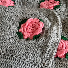 Load image into Gallery viewer, This beautifully crafted handmade vintage crochet blanket throw features gray granny squares, each with a central dimensional pink rose with green leaves. This super cozy throw is perfect for curling up in front of the fire with a good book or watching a movie.
In excellent condition.
Measures 60 x 68 inches