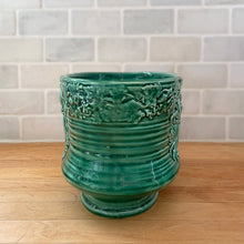 Load image into Gallery viewer, Vintage green glazed Bacchante oval planter jardiniere, shape 115, features embossed toga-clad figures with grapevine detail at the rim. Crafted by Sylvac, England, 1930s 1940s. A nice sized piece for your favourite bulbs and houseplants or use as decor.
In excellent condition, no chips/cracks/repairs.
Measures 9 1/4 x 5 3/4 x 5 1/2 inches