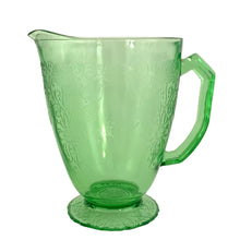 Load image into Gallery viewer, Vintage Florentine 1 green uranium depression era glass 36oz pitcher features a scalloped foot and glows beautifully under black light. Crafted by Hazel-Atlas Glass, USA, 1932 - 1935. Perfect for adding a touch of sophistication to any table setting or display in your uranium glass collection!
In excellent used vintage condition, no chips, minor wear.
Measures 7 x 4 7/8 x 6 3/4 inches (incl. handle/spout)