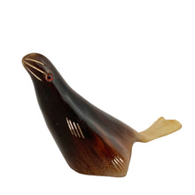 Load image into Gallery viewer, This charming vintage hand-carved sea lion sculpture is crafted from polished buffalo horn, showcasing beautiful natural color variations from deep black to translucent ivory. The minimalist folk art style, smooth contours, and subtle carved details give this piece a warm, tactile character that feels both playful and timeless.
Each angle highlights the artisan’s hand—no two horn carvings are ever exactly alike. A lovely addition to a coastal décor display, folk art collection, or curio shelf.