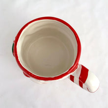 Load image into Gallery viewer, A hand painted vintage happy Santa Claus ceramic mug decorated in red, white, green and black plus a candy cane striped handle! Crafted in Taiwan, circa 1980s. Add charm to your Christmas decor by filling this adorable mug with candy canes! In excellent vintage condition, free from chips/cracks/repairs with one minor spot of glaze loss on the green holly leaf. Measures 3 1/2 x 3 1/4 inches