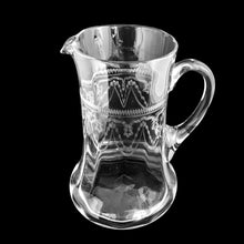 Load image into Gallery viewer, Angled front view of Antique Heisey Glass No. 3350 clear cylinder pitcher with needle-etched Trefoil tatting pattern, applied handle, flared base, black background — USA, c. 1917–1928