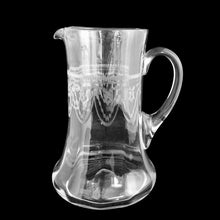 Load image into Gallery viewer, Side view of Heisey No. 3350 hand-blown glass pitcher, needle-etched Trefoil tatting band with swag and bow motifs, panel-optic body, flared foot, black background — antique American barware