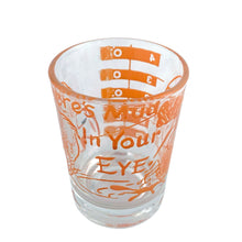 Load image into Gallery viewer, Vintage Here's Mud in Your Eye novelty bar measure featuring a clumsy fisherman and 1, 2, 3 and 4 ounce levels printed in orange on clear glass. Maker unknown, 1970s.
In as found vintage condition, no chips, some wear to inside bottom.
Measures 2 1/4 x 3 inches