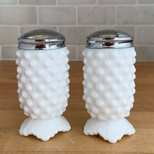 Load image into Gallery viewer, Pair of vintage "Hobnail" milk glass salt and pepper shakers (#3609) with metal lids. Crafted by Fenton Art Glass, USA, 1970 - 2012. Add a bit of charm and elegance to your table with these beauties! In excellent condition, free from chips. Chrome is intact. Each shaker measures 1 3/4 x 3 1/2 inches