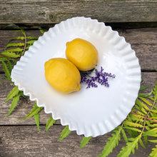 Load image into Gallery viewer, This vintage "Hobnail" pressed milk glass low banana stand brings all the drama! It features a low foot, with folded sides and a crimped edge. Crafted by the Fenton Art Glass, USA, circa 1970s. A graceful piece of pressed glass in a classic pattern that will always be in style no matter your decor style. Fill with your favourite fruits and display! In excellent condition, free form chips/cracks. Measures 12 x 9 x 4 1/2 inches