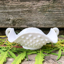 Load image into Gallery viewer, This vintage milk glass "Hobnail" 7 inch pressed glass handled bon bon dish brings all the drama in a small package! It features a square bowl with scalloped edge and two handles. Crafted by the Fenton Art Glass, USA, circa 1960s. A graceful piece of pressed glass in a classic pattern that will always be in style no matter your decor style! Fill with your favourite candies, nuts or snacks. In excellent condition, free form chips/cracks. Measures 7 x 7 x 2 1/2 inches (from corner to corner)