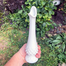 Load image into Gallery viewer, This vintage milk glass "Hobnail" handled swung bud vase brings all the drama in a small package! Crafted by the Fenton Art Glass, USA, circa 1960s. A graceful piece of mold blown and hand pulled glass in a classic pattern that will always be in style no matter your decor style! In excellent condition, free form chips/cracks. Measures 2 1/2 x 9 1/8 inches