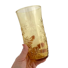 Load image into Gallery viewer, Vintage honey gold "Springsong" cooler glass impressed with daisy flowers on a textured surface. Crafted by Anchor Hocking, USA, circa 1970s. Perfect for a tall cool glass of your favourite beverage or repurpose as a vase, paint brush holder. In excellent condition, free form chips. Measures 3 1/2 x 7 inches