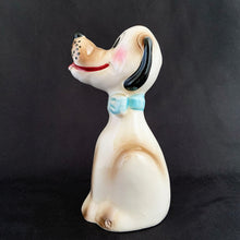 Load image into Gallery viewer, Show off the playful charm of this adorably freckle faced ceramic hound dog figurine! Its wide-eyed expression and pink tongue will add a dash of fun to any room. This beige, tan and black canine features a classic blue bow tie and is sure to charm everyone who sees it! In excellent condition, free form chips/cracks/repairs. Marked "Japan" on the bottom. Measures 2 x 4 1/2 inches