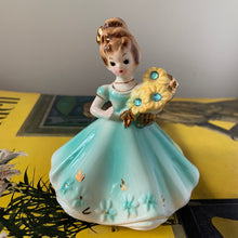 Load image into Gallery viewer, This sweet vintage mid-century figurine is one of the Birthday of the Month series designed by Josef Originals of Japan, circa 1950s. This sweet girl is beautifully styled wearing a full length dress hand painted in aqua and gold, holding a basket of yellow flowers with an aquamarine birthstone in the centre of each flower. In excellent condition, free from chips/cracks/repairs. Marked on the bottom "Josef Originals © Japan" Measures 3 1/2 x 4 inches