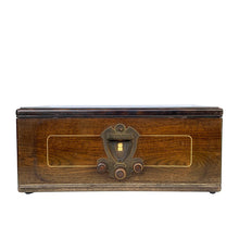 Load image into Gallery viewer, Front view of RCA Victor radio cabinet with decorative gold border, central tuning dial and three wooden knobs