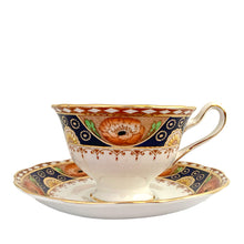 Load image into Gallery viewer, Vintage bone china Avon shaped Imari-style teacup and saucer, "Un-Named Set #562". Each piece has a lovely scalloped edge featuring hand painted cobalt blue panels inset with orange poppy and yellow daisy flowers, topped by a band of white diamonds, trimmed with gold gilt. Crafted by Royal Albert, England, 1930s. Makes a beautiful gift or addition to your collection!