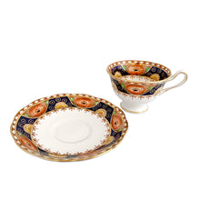 Load image into Gallery viewer, Vintage bone china Avon shaped Imari-style teacup and saucer, "Un-Named Set #562". Each piece has a lovely scalloped edge featuring hand painted cobalt blue panels inset with orange poppy and yellow daisy flowers, topped by a band of white diamonds, trimmed with gold gilt. Crafted by Royal Albert, England, 1930s. Makes a beautiful gift or addition to your collection!