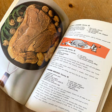 Load image into Gallery viewer, This vintage softcover It's Mainly Because of the Meat Cookbook. There are 145 pages with recipes and colour illustrations and photography. Dominion Stores, Canada, 1969. A handy guide to bring your favourite foods to life!
In excellent vintage condition, appears unused. Age-related foxing/yellowing of the pages.
Measurements 5 3/4 x 9 inches