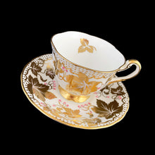Load image into Gallery viewer, A gorgeous white bone china teacup and saucer featuring gold gilt ivy leaves and trim with pink berries florals. Crafted by Royal Chelsea, England, 1940s. A lovely addition to any china collection!
In excellent vintage condition, no chips, cracks or repairs.
Teacup measures 3 1/2 x 2 5/8 inches
Saucer measures 5 1/2 inches