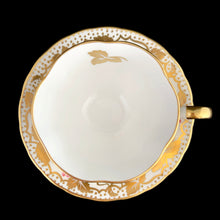 Load image into Gallery viewer, A gorgeous white bone china teacup and saucer featuring gold gilt ivy leaves and trim with pink berries florals. Crafted by Royal Chelsea, England, 1940s. A lovely addition to any china collection!
In excellent vintage condition, no chips, cracks or repairs.
Teacup measures 3 1/2 x 2 5/8 inches
Saucer measures 5 1/2 inches