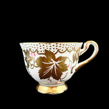 Load image into Gallery viewer, A gorgeous white bone china teacup and saucer featuring gold gilt ivy leaves and trim with pink berries florals. Crafted by Royal Chelsea, England, 1940s. A lovely addition to any china collection!
In excellent vintage condition, no chips, cracks or repairs.
Teacup measures 3 1/2 x 2 5/8 inches
Saucer measures 5 1/2 inches