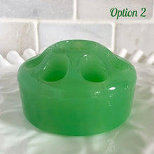 Load image into Gallery viewer, Wonderful vintage jadeite green glass flowerlite flower frog featuring 7 outer holes for flower stems and 1 central hole which is meant to hold a taper candle. Crafted by Fenton Art Glass, USA, circa 1920s, unmarked. This frog appears on page 141 of the Bull Book on Flower Frogs. A hard-to-find piece to add to your vintage glass collection. Would look heavenly paired with a jadeite bowl to create a beautiful candle lit floral centrepiece!