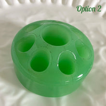 Load image into Gallery viewer, Wonderful vintage jadeite green glass flowerlite flower frog featuring 7 outer holes for flower stems and 1 central hole which is meant to hold a taper candle. Crafted by Fenton Art Glass, USA, circa 1920s, unmarked. This frog appears on page 141 of the Bull Book on Flower Frogs. A hard-to-find piece to add to your vintage glass collection. Would look heavenly paired with a jadeite bowl to create a beautiful candle lit floral centrepiece!