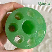 Load image into Gallery viewer, Wonderful vintage jadeite green glass flowerlite flower frog featuring 7 outer holes for flower stems and 1 central hole which is meant to hold a taper candle. Crafted by Fenton Art Glass, USA, circa 1920s, unmarked. This frog appears on page 141 of the Bull Book on Flower Frogs. A hard-to-find piece to add to your vintage glass collection. Would look heavenly paired with a jadeite bowl to create a beautiful candle lit floral centrepiece!