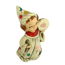 Load image into Gallery viewer, Josef Originals Libra Zodiac wizard figurine, right three-quarter view from slightly above, showing the smiling hand-painted face, tall wizard hat with celestial motifs, cream robe with teal and gold stars, pink dots, and cross details, cloud-shaped Libra medallion held at right shoulder
