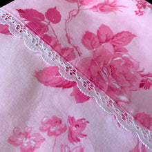 Load image into Gallery viewer, This lovely vintage "Kensington" pink flat bed sheet features a pattern pink roses and the band has a white lace detail. This 50% polyester / 50% cotton sheet fits a double/full sized bed. Crafted by Cannon Royal Family, USA, circa mid 1970s. A beautiful addition to your bedding collection, or repurpose for crafts, quilting or garment making. In excellent condition free from stains/tears. Original label present and colours are vivid and appears to be unused. Fits a double/full size mattress 81 x 104 inches