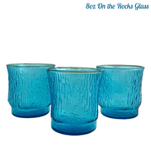 Load image into Gallery viewer, A selection of vintage mid-century modern "Pagoda" glass tumblers in striking laser blue. Crafted by Anchor Hocking, USA, circa 1960s. This glassware features a unique bark-like texture and is the perfect addition to your Tiki or Chinoiserie style drink and barware! All pieces are excellent condition, free from chips. 8oz On the Rocks Glass