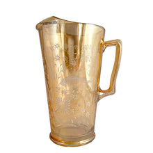 Load image into Gallery viewer, Gorgeous vintage mid century era iridescent marigold carnival glass pitcher featuring the "Late Sunflowers" pattern of wildflowers and ferns in white. Crafted by Jeannette Glass, USA, 1950s. The perfect way to serve your favourite beverage with vintage flare! In excellent condition, minor wear. Flea bites along the mold release at the interior rim, see photos. Measures 5 5/8 x 9 5/8 inches Capacity 56 ounces