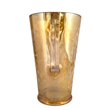 Load image into Gallery viewer, Gorgeous vintage mid century era iridescent marigold carnival glass pitcher featuring the "Late Sunflowers" pattern of wildflowers and ferns in white. Crafted by Jeannette Glass, USA, 1950s. The perfect way to serve your favourite beverage with vintage flare! In excellent condition, minor wear. Flea bites along the mold release at the interior rim, see photos. Measures 5 5/8 x 9 5/8 inches Capacity 56 ounces