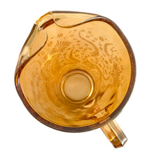 Load image into Gallery viewer, Gorgeous vintage mid century era iridescent marigold carnival glass pitcher featuring the "Late Sunflowers" pattern of wildflowers and ferns in white. Crafted by Jeannette Glass, USA, 1950s. The perfect way to serve your favourite beverage with vintage flare! In excellent condition, minor wear. Flea bites along the mold release at the interior rim, see photos. Measures 5 5/8 x 9 5/8 inches Capacity 56 ounces