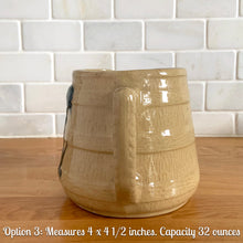 Load image into Gallery viewer, Vintage natural yellow ware strapped barrel milk pitcher featuring navy lily in bas relief with rope style handle, No. 21171. Crafted by Robinson Ransbottom Pottery Co., USA, 1930s.
Enhance your home's decor with this beautiful piece of primitive farmhouse tableware. A wonderful addition to any art pottery collection!
Option 3: Measures 4 x 4 1/2 inches. In excellent vintage condition, no chips/cracks/repairs with age-related crazing and typical manufacturer's glaze pops. Unmarked. Capacity 32 ounces