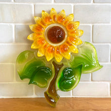 Load image into Gallery viewer, Brighten up your decor with this delightful vintage lucite wall plaque of a yellow, orange and green sunflower! Handmade by Ideal Gifts, circa 1970s. This piece has a metal hanger on the back for ease of displaying on a wall. This happy flower will certainly brighten up your decor! In excellent condition! Original sticker. Measures 8 x 9 1/4 inches
