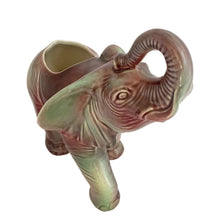 Load image into Gallery viewer, Vintage mid-century era figural lucky elephant ceramic plant in shakes of cranberry, green, yellow and gray. Marked Made in USA. Bring some luck to your gardening with this sweet, trunk up, planter!
In excellent condition, no chips/cracks/repairs.
Measures 9 x 4 x 7 7/8 inches