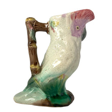 Load image into Gallery viewer, Antique majolica figural white and pink cockatoo parrot ceramic pitcher with green botanical base and brown bamboo-style handle. Crafted by Georges Jones, England, in the late 19th century (1880s). A wonderful piece of whimsical majolica for any collector and lends itself nicely to a tropical or Tiki themed decor!
In good used vintage condition, no chips. Age-related crazing and typical manufacturing glaze bubbles present. See photos.
Measures 5 x 2 1/2 x 6 inches