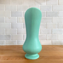 Load image into Gallery viewer, Rare vintage mid-century matte turquoise vase with decorative handle. Crafted by McCoy Pottery, 1950s. This vase is must for any art pottery collector! Makes a perfect mid-century decor statement or give as a gift.
In good condition, slim chip to the handle, no cracks/repairs. Maker's mark on the bottom.
Measures 6 x 9 inches (incl. handle/spout)