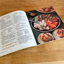 Load image into Gallery viewer, This vintage softcover cookbook features recipes that require very little cooking. Its 64 pages are filled with yummy recipes along with many colourful illustrations and photographs. From the food editors of McCall's Magazine, published by Advance Publishers, USA, 1965. In great vintage condition with normal age-related yellowing of the internal pages.