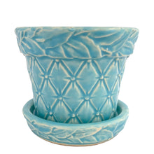 Load image into Gallery viewer, McCoy Tierra Cushion planter, side view showing the leaf garland band at the rim and the quilted lower body in aqua glaze with white relief highlights