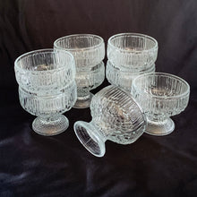 Load image into Gallery viewer, A unique set of six vintage clear pressed glass sherbet dishes that offer a nod to the Scandinavian art glass designers of the mid-century. These nicely weighted glacier style sherbets have a smooth texture of a melting wall of ice right down to their flared foot. Perfect for adding a mid mod touch to your desserts! In excellent condition, free from chips/cracks. Measures 3 3/4 x 3 1/2 inches Capacity 10 ounces