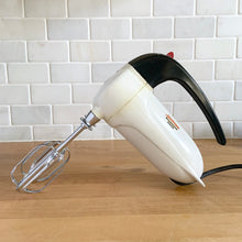 Load image into Gallery viewer, Fabulous vintage white and black Sunbeam Mixmaster Junior hand mixer, Model J. Crafted by the Sunbeam Corporation, USA, circa 1950. The power and quality craftsmanship of these mixers is unmatched and are made to last a lifetime. A must-have for any baker or appliance collector!
Tested. In good working order.
Mixer measures 7 1/4 x 3 x 6 inches (10 3/4 inches tall with beaters)