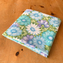 Load image into Gallery viewer, Vintage Monticello Celestial Blue Aloha twin flat bed sheet featuring a tropical all-over print of flowers in shades of blue, turquoise, green and purple. Crafted by Cannon, USA, 1972 – 1975. The vibrant textile is perfect for adding a touch of island flower power to your bed linens or repurpose for crafting or dressmaking.
In excellent like-new condition, no stains/tears. Original tag.
Measures 72 x 98 inches